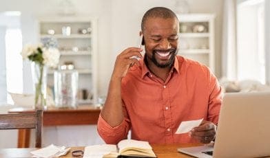 Man smiling using laptop at home